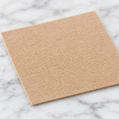 Närbild på beige textilplåster med mjuk vävd yta