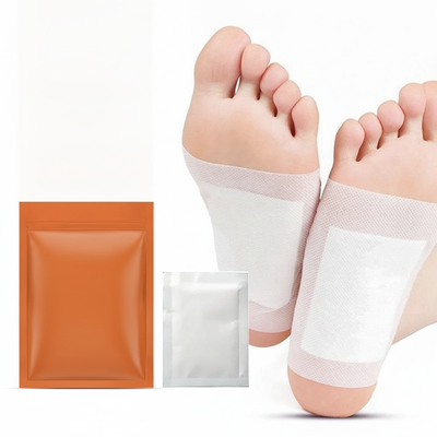 Two herbal foot patches applied to bare feet