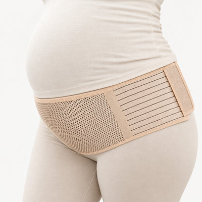 Beige gravidbälte buret under magen över leggings och tröja