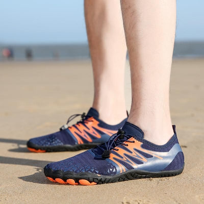 Blå barfotaskor som bärs på stranden