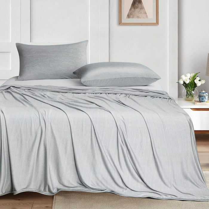Kylfilt draperad på en säng i skandinaviskt sovrum