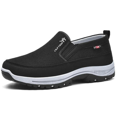 Musta slip on -kenkä holvikaarituellisella pohjalla valkoisella taustalla