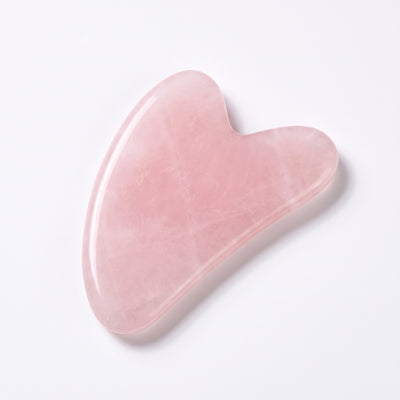 Gua sha tool angled on white seamless backdrop