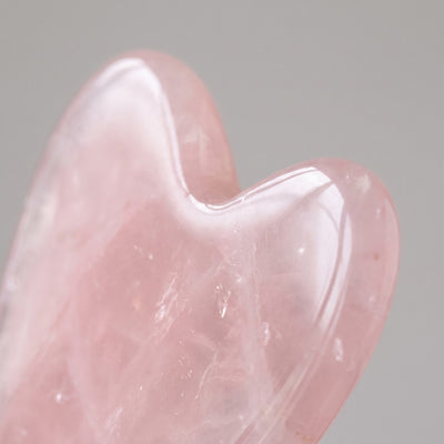 Close-up of polished edge and notch of pink gua sha