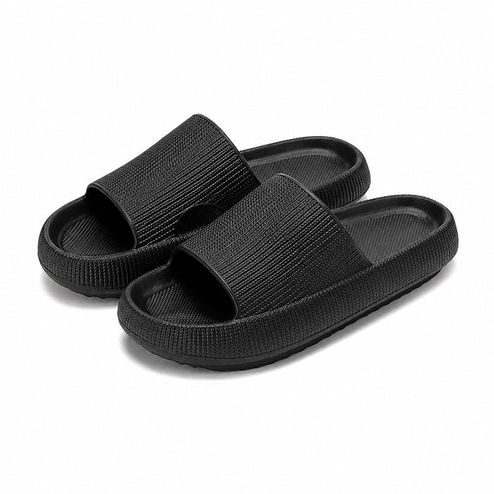 Svarta slip-in-tofflor med platåsula, ett par på vit bakgrund