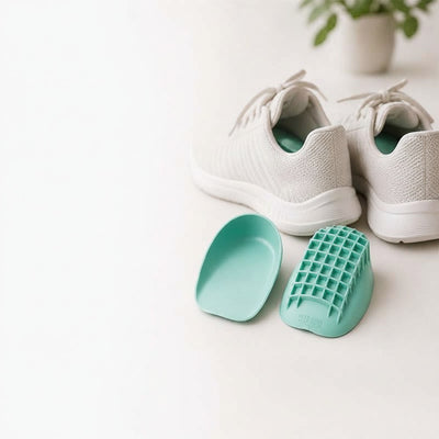 Blågrønne hælkopper ved siden af hvide sneakers på ren overflade