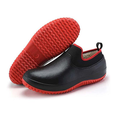 Svarta slip-on-vinterskor med röd sula och röda detaljer