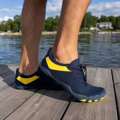 Marinblå barfotasko med gul detalj på en brygga